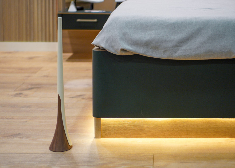 Shoe horn next to a modern bed and nightstand