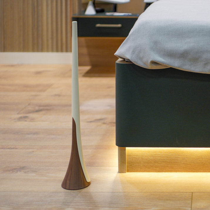 Shoe horn next to a modern bed and nightstand