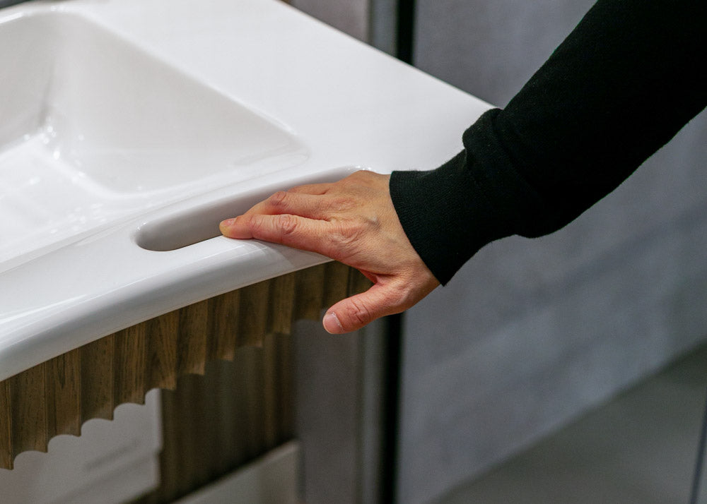 Person holding a white sink with an integrated hand hold