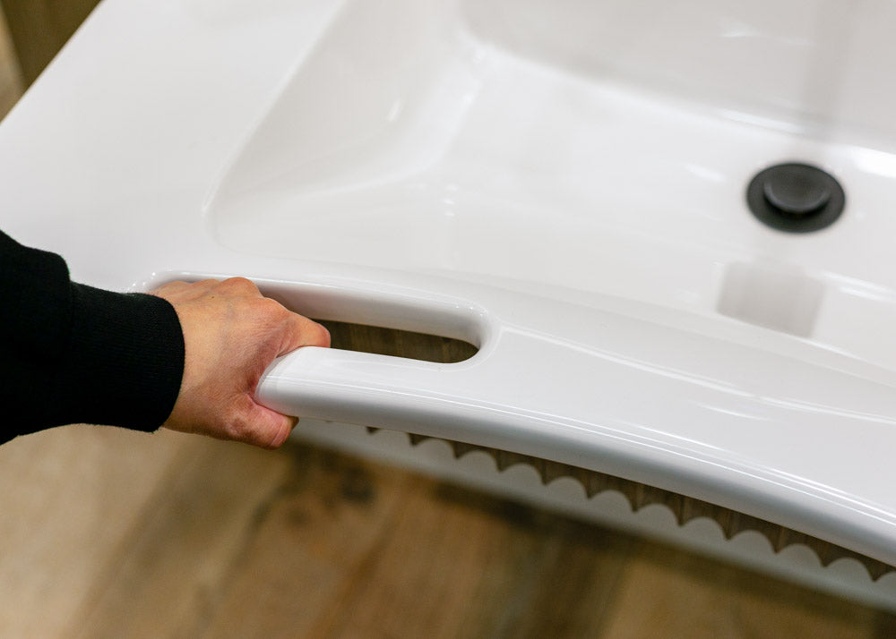 Person holding a hand rail integrated into a sink