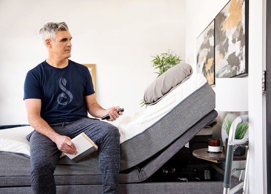Man sitting on a adjustable bed in a modern bedroom