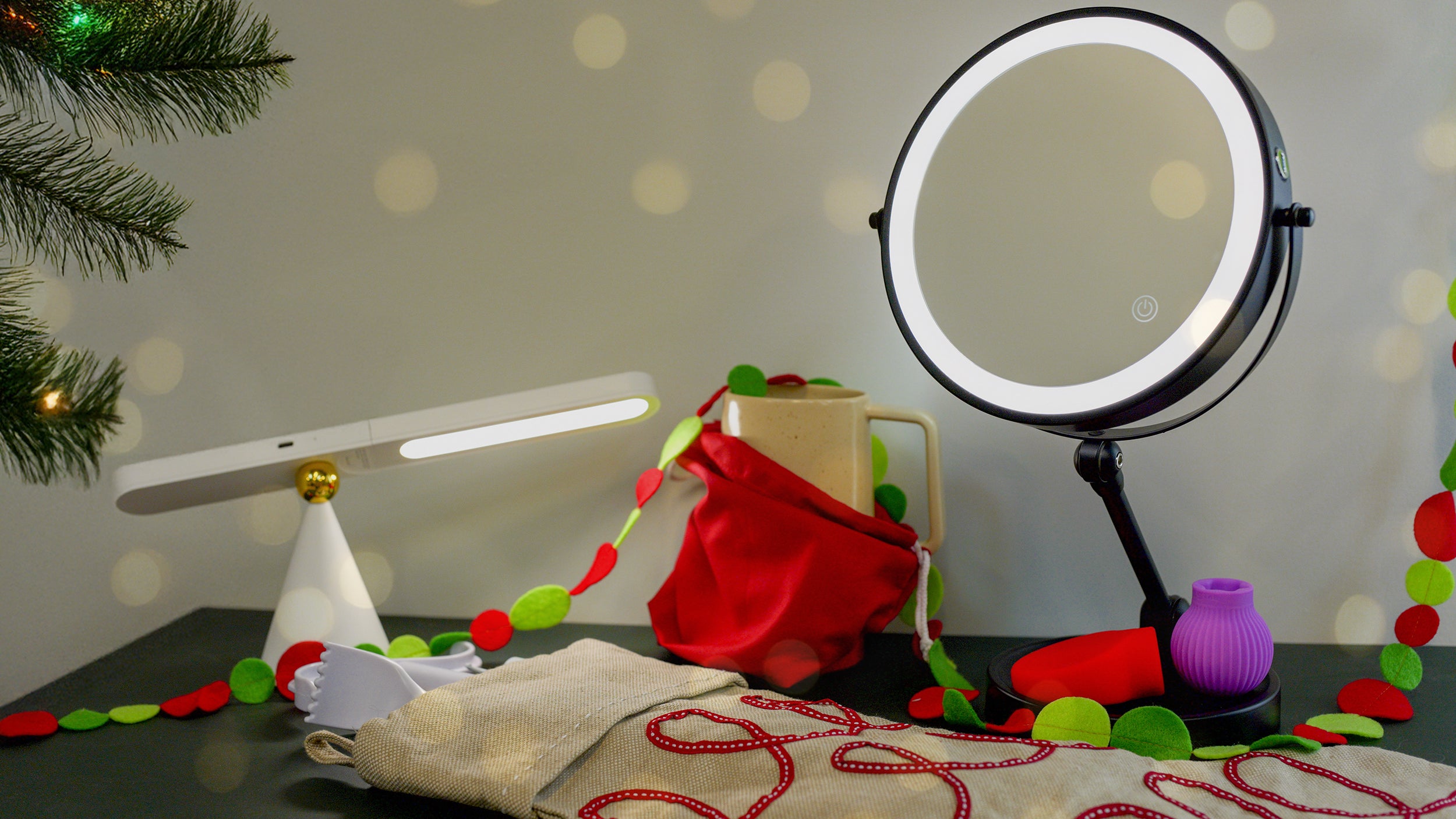 Round makeup mirror with LED light on a table with decorative items and a blurred background.