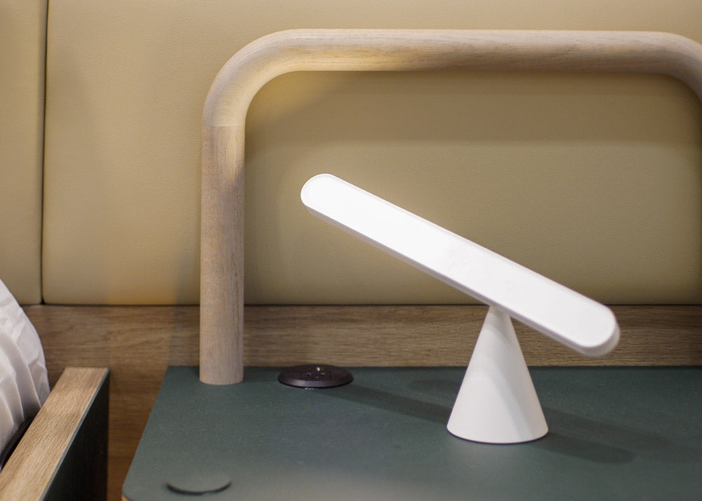Modern table lamp with a minimalist design on a green surface.