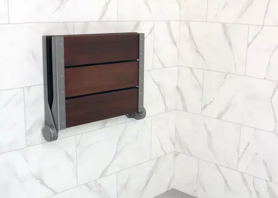 Folded-up shower seat on a tiled wall
