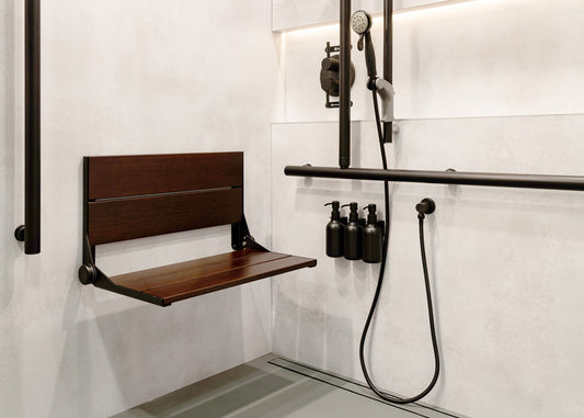Wall-mounted shower seat in a modern bathroom with shower fixtures and bottles.