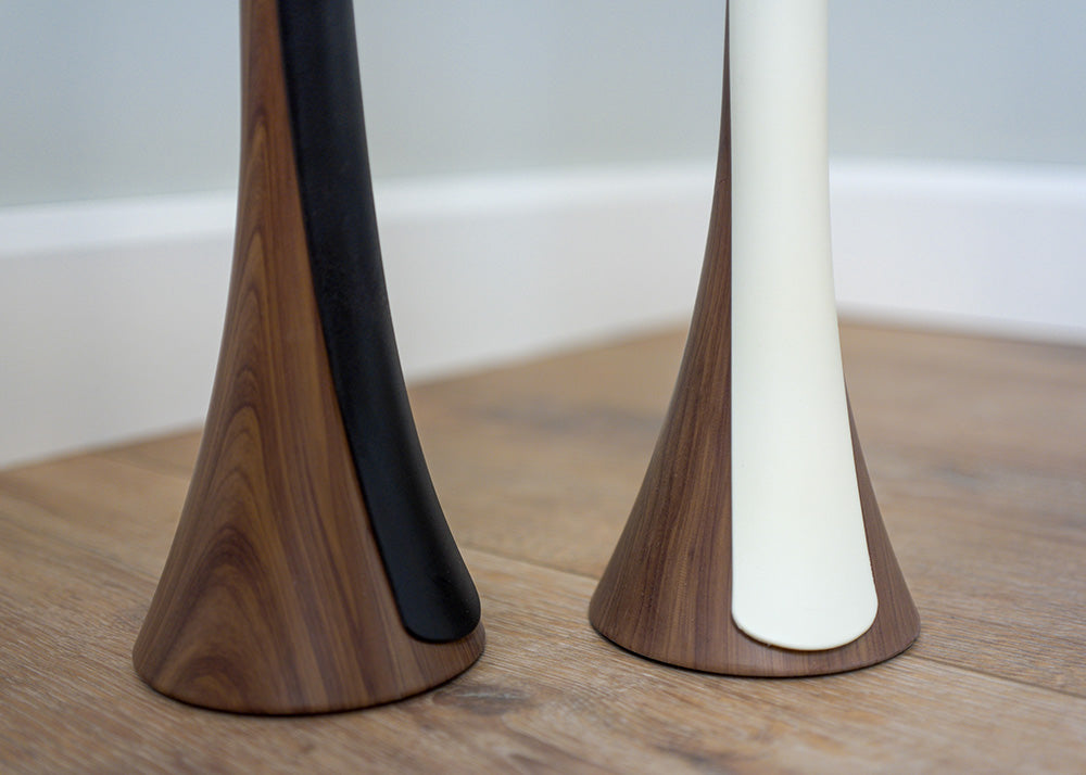 details of two shoehorns with white and black tongues on wood-like bases