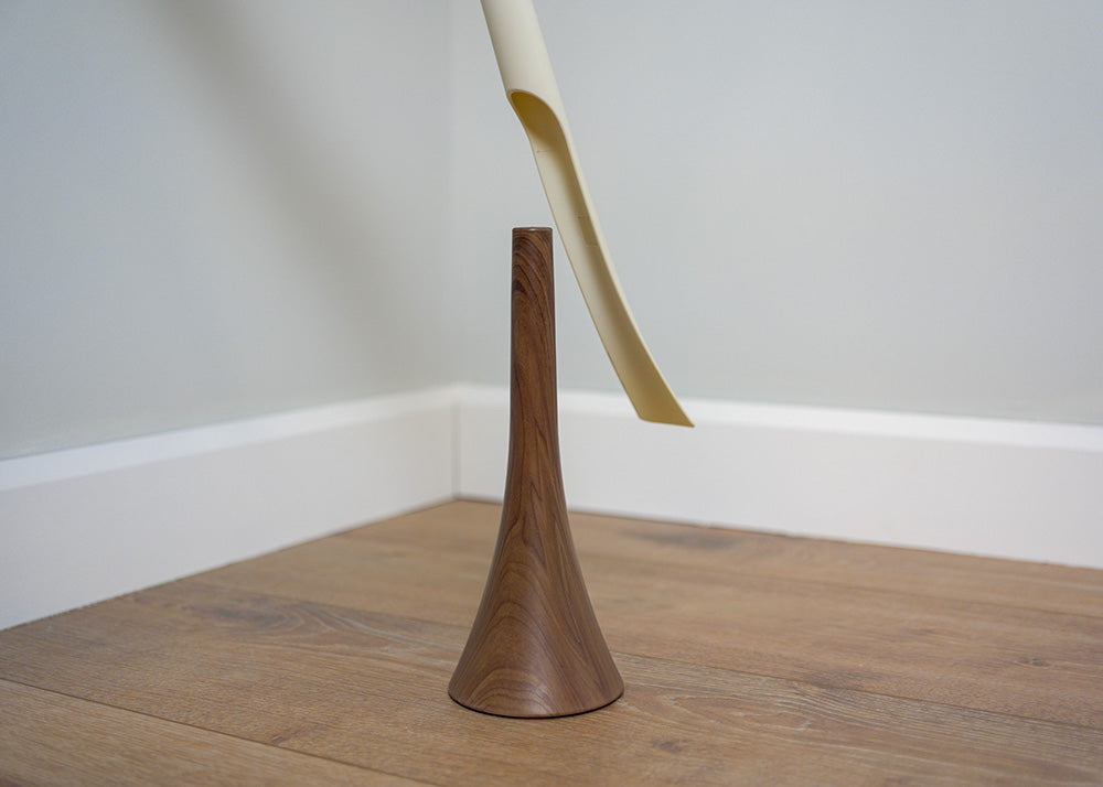 wood textured shoehorn base with a white shoehorn hovering above
