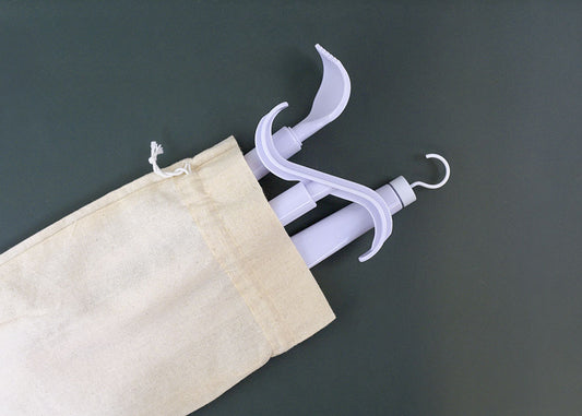 White hooks in various designs sticking out of a canvas bag on a dark background