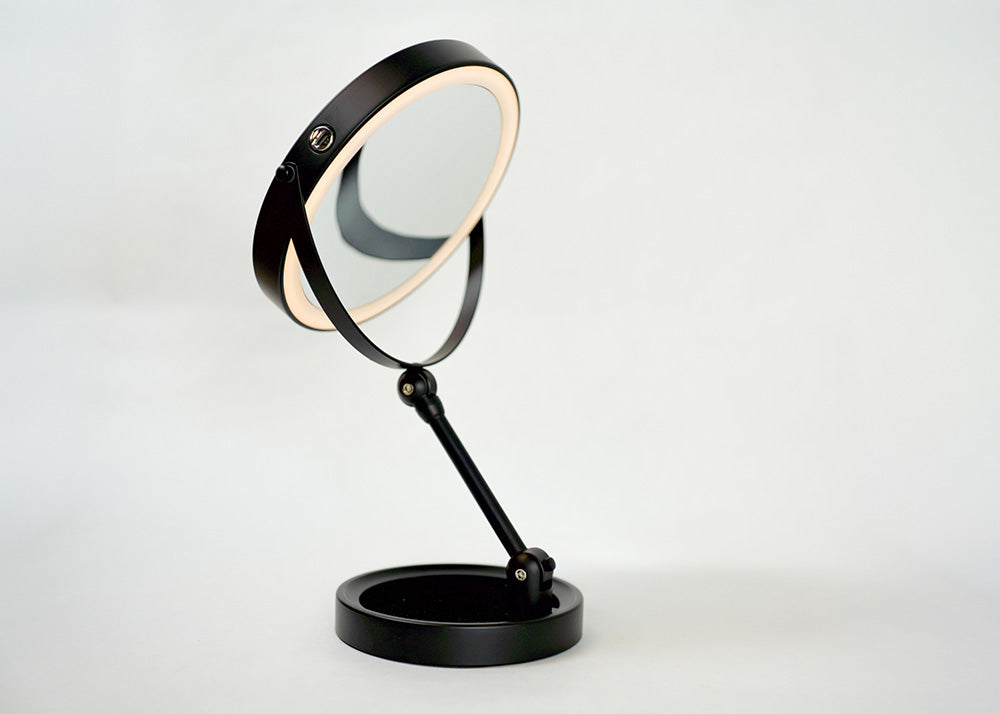 Black magnifying mirror on a white background