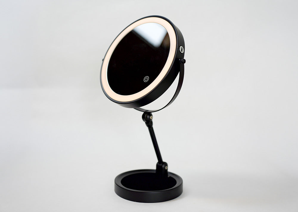 Black makeup mirror with LED lights on a white background